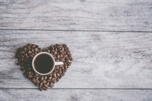 Cup of coffee in heart shape of beans