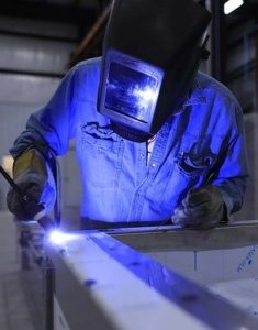 Man welding metal with welding mask on