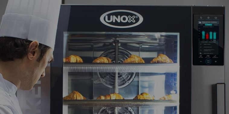 Unox oven with croissants inside and a chef