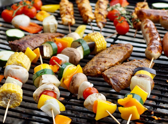 Vegetable skewers and meat on grill