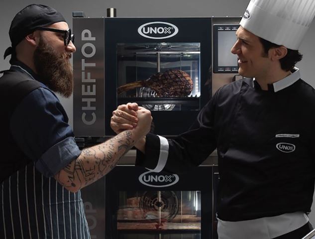 Chefs locking hands in front of Unox oven