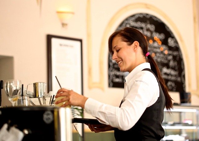 Smiling waitress with tray serving drinks