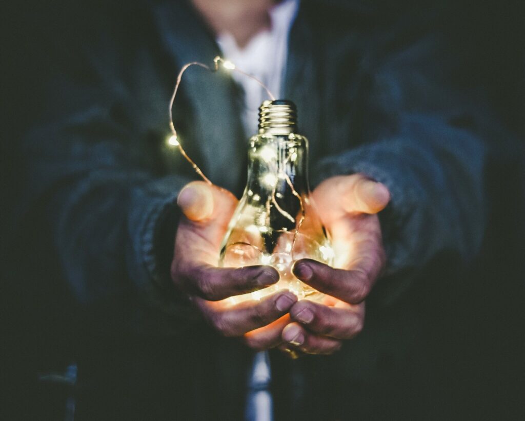 Lit light bulb in cupped hands