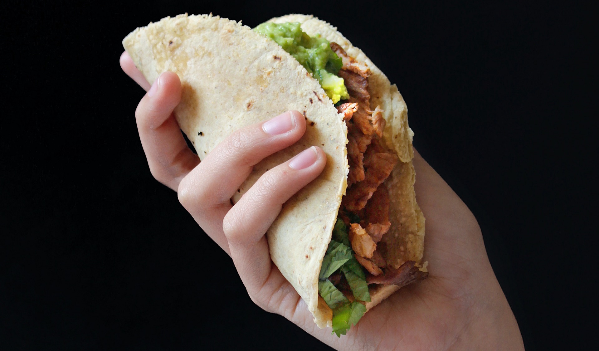 Hand holding kebab with fillings