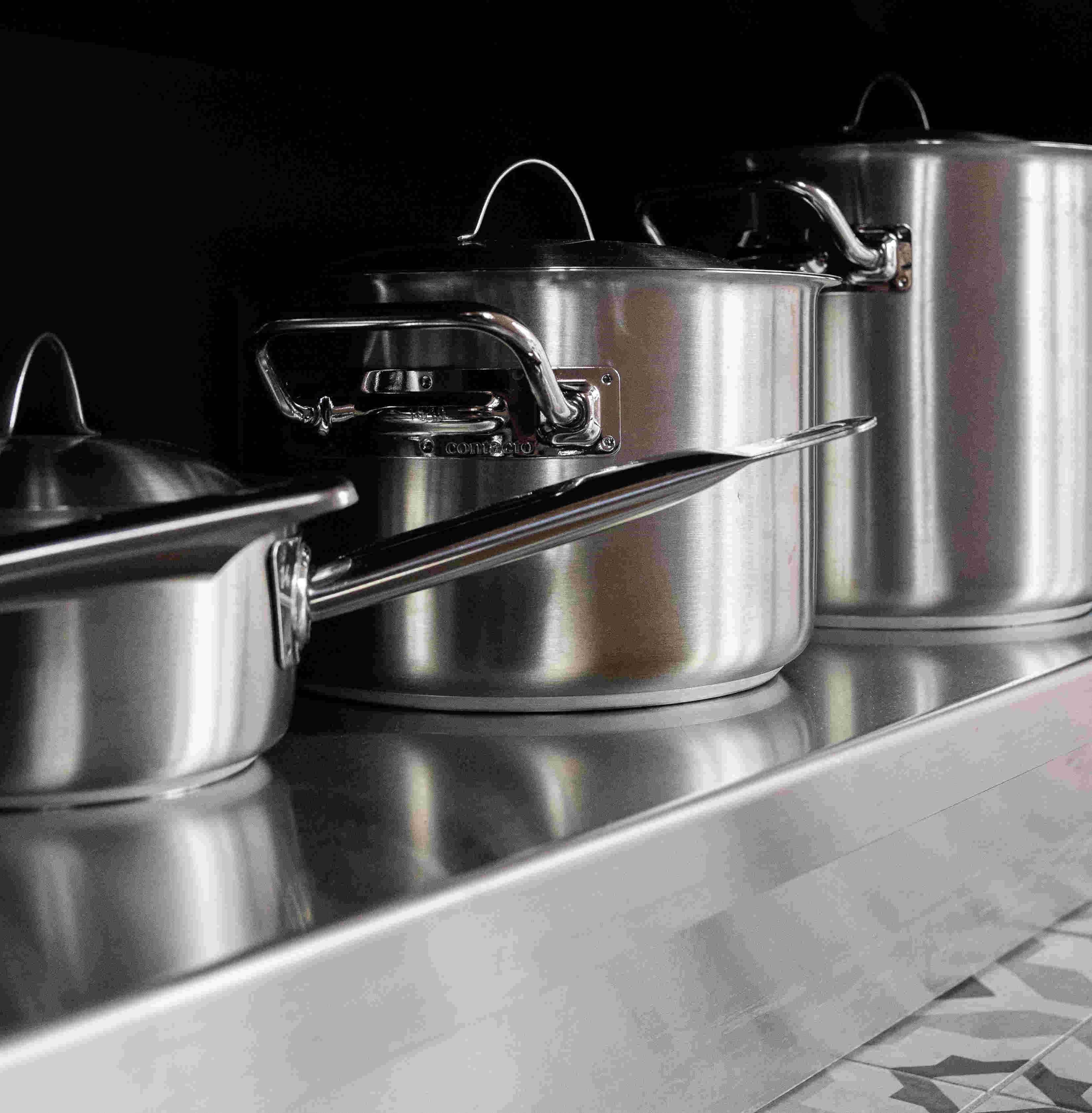 stainless steel saucepans on a stainless steel shelf
