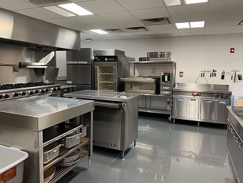 commercial kitchen with stainless steel cupboards, sinks, equipment and extraction